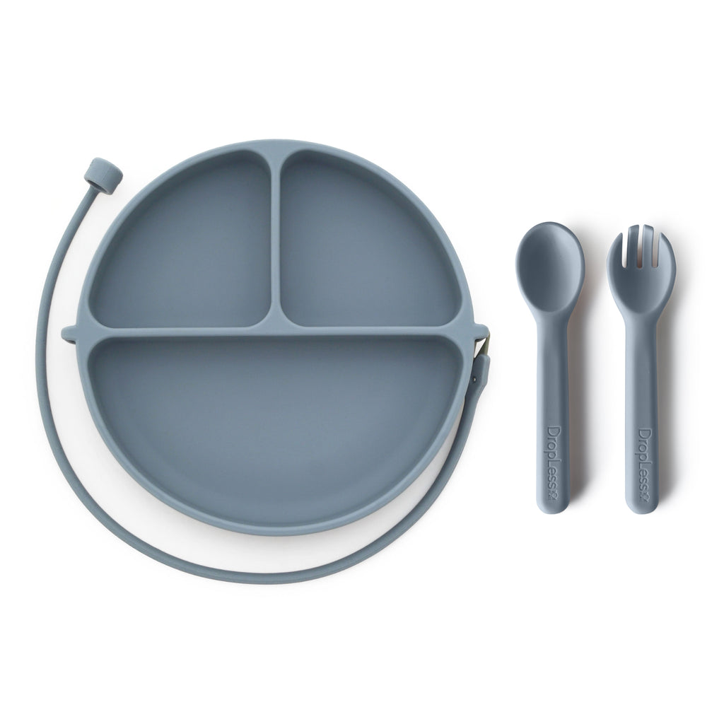 Gray silicone plate with divided sections and a spoon and fork on a white background